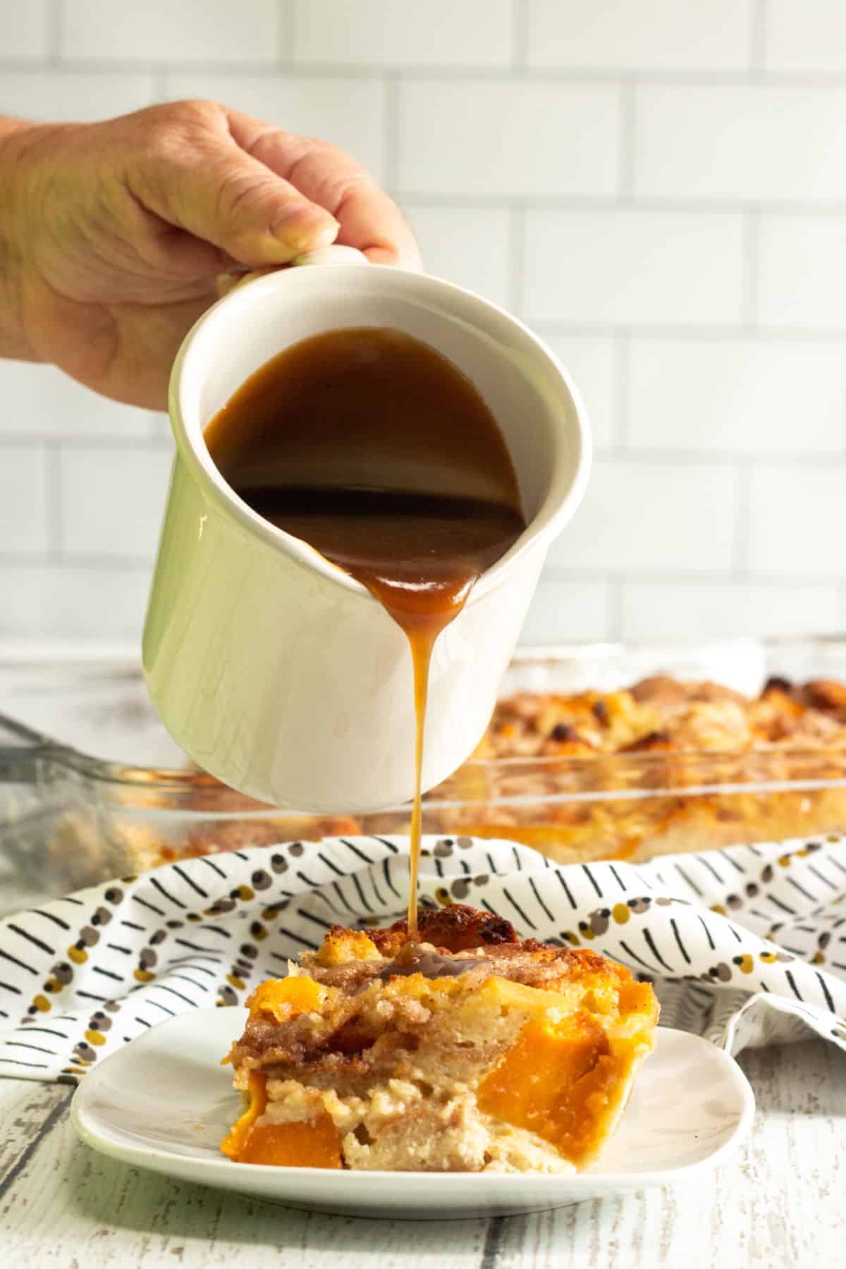 maple sauce being poured on sweet potato bread pudding